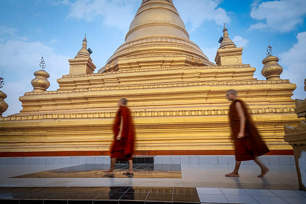 Monks at the Mingun Pahtodawgyi incomplete monument stupa in Mingun, approximately 10 kilometres (6.2 mi) northwest of Mandalay in Sagaing Region in central Myanmar (formerly Burma). The crack was caused by an earhquake  23 March 1839