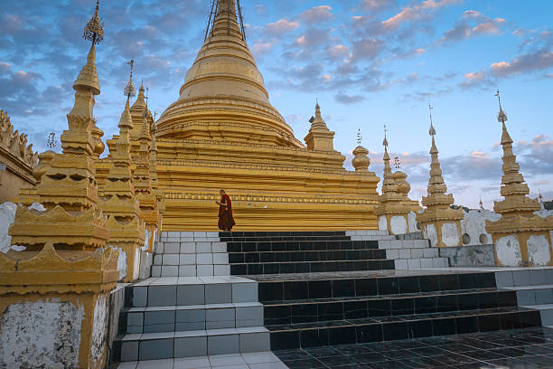 Monk walking down the stairs of the kuthodaw pagoda in mandalay, myanmar
