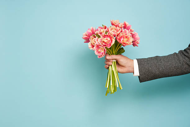 istock Romantic man presents a bouquet of tulips 2208857987