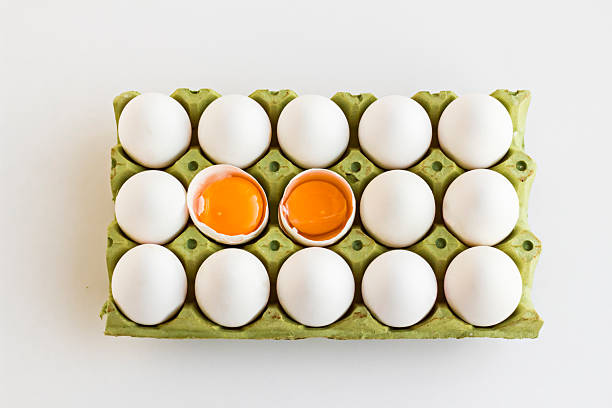 Top view of fresh,organic fifteen eggs in the cardboard box,two eggs broken.