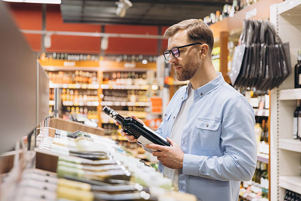 istock Customer Choosing Wine Bottle in Supermarket Drinks Section 2208865586
