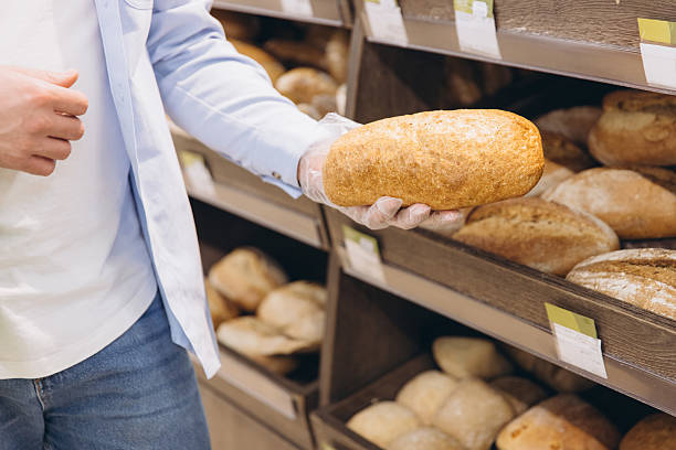 istock Customer choosing fresh bread loaf in supermarket bakery section 2208866264