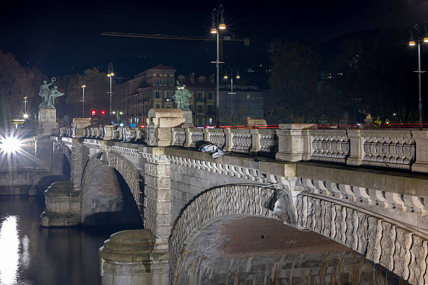 Turin, Italy - Nov 08 2021: The Ponte Umberto I bridge at night with lights reflecting on the water