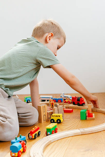 istock Child Playing with Toy Train on Wooden Track 2208871867