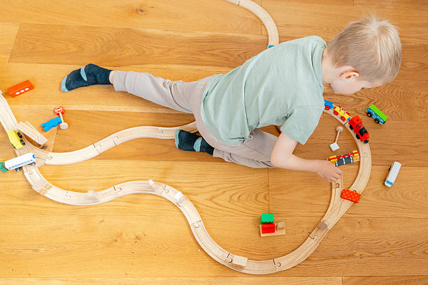 istock Child Playing with Toy Train on Wooden Floor 2208872032
