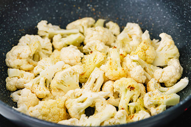 istock Seasoned cauliflower cooks in a hot skillet. 2208876873