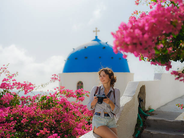 Woman with camera exploring Santorini island