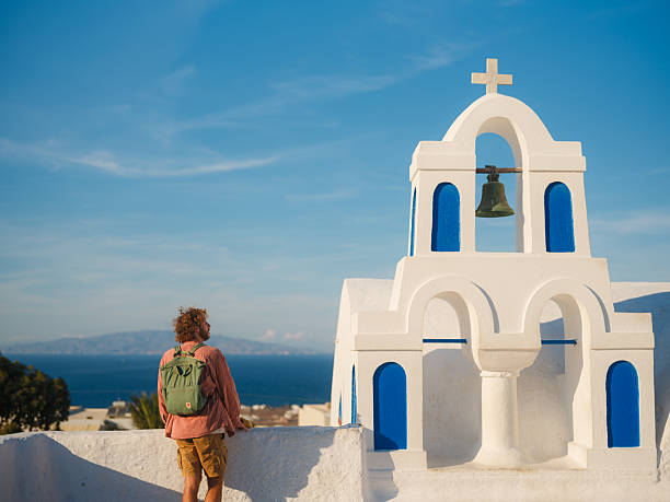 Serene man walking on Santorini island in Greece and looking at views