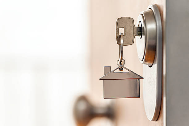 istock House key and keychain inserted into a high security door lock. 2208883880