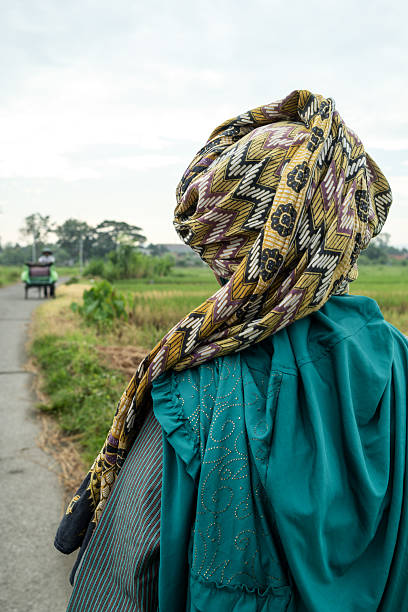 istock Javanese woman wearing traditional headscarf looking at cycle rickshaw 2208895702