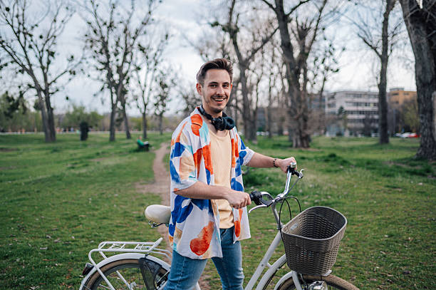 istock Young stylish man walking with his bicycle in a park 2208898054