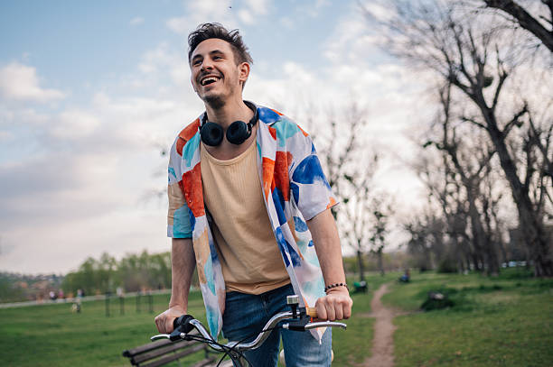 istock Young man enjoying riding bicycle in park during summer day 2208898060