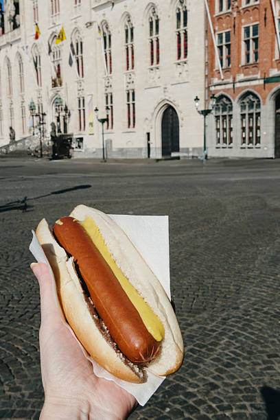 istock A sausage sandwich in a man's hand. 2208900196