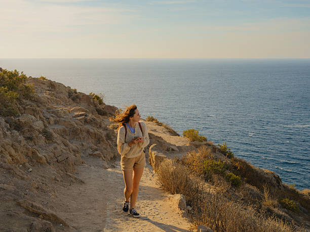 istock Woman exploring scenic Santorini island and looking at seaside 2208900413