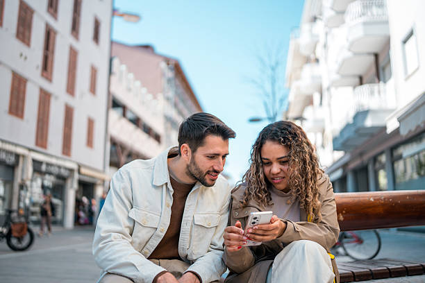 istock Young Caucasian Couple Exploring Outdoors with Smartphone on a Bright Sunny Day 2208909464