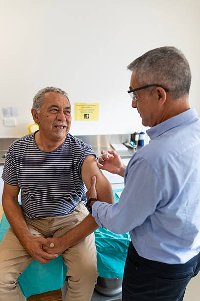 Senior Australian Aboriginal man receiving a vaccination injection
