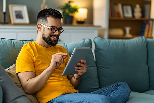 istock Man relaxing at home and using digital tablet at home. 2208917318