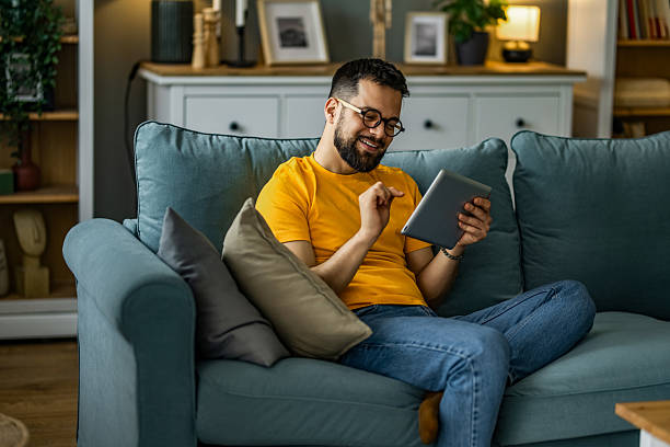 istock Man relaxing at home and using digital tablet at home. 2208917975