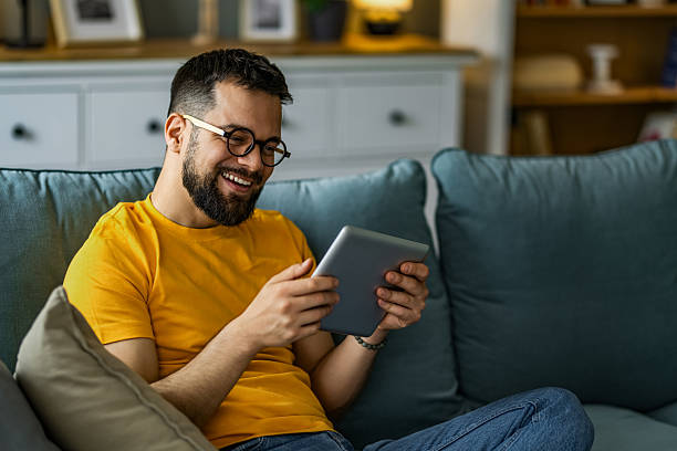 istock Man relaxing at home and using digital tablet at home. 2208918064