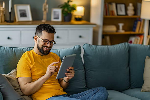 istock Man relaxing at home and using digital tablet at home. 2208918697