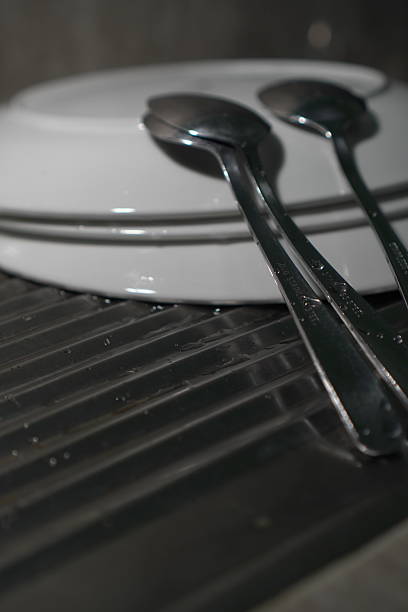 istock Stainless steel spoons atop stacked white plate 2208927575