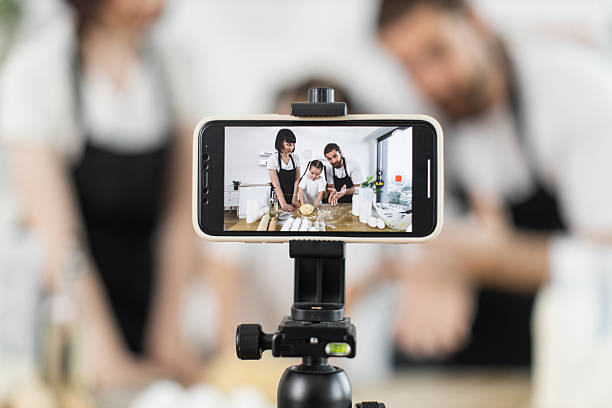 istock Family recording cooking vlog together while kneading dough in home kitchen setup 2208927748