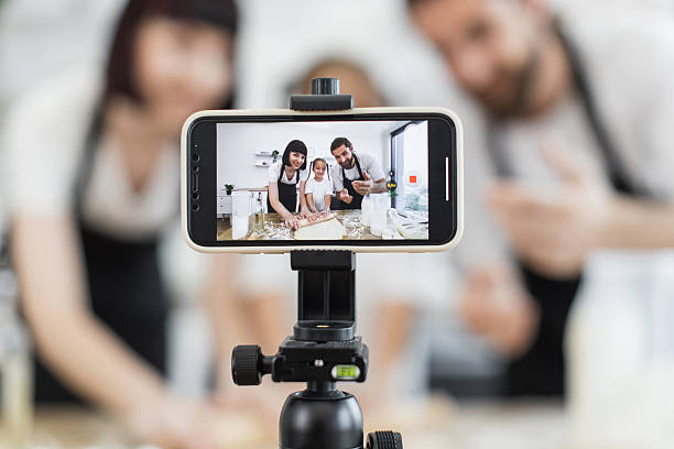 istock Caucasian family recording cooking tutorial by kneading dough on kitchen counter 2208927809