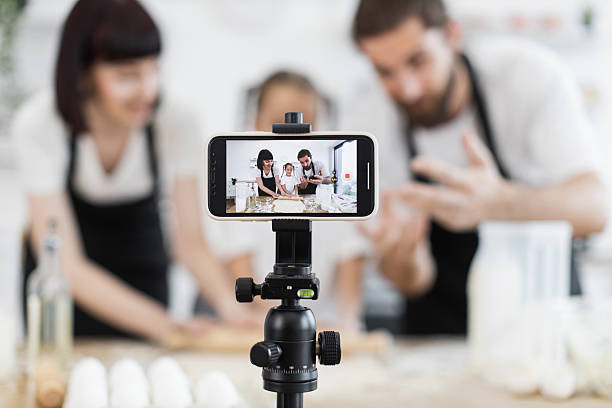 istock Family recording baking session in kitchen using smartphone on tripod 2208927812