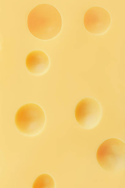 istock Textured Emmental cheese as a background Swiss holey maasdam cheese wallpaper. Pattern. 2208932316