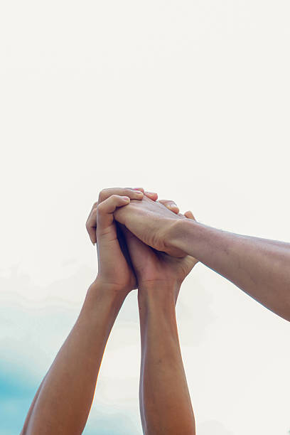 A group unites by raising their hands together in a display of unity, strength and cooperation