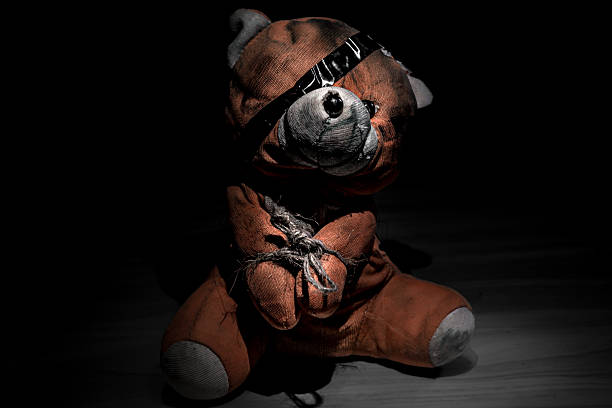 istock Disturbing Teddy Bear Bound and Blindfolded in Darkness 2208934162