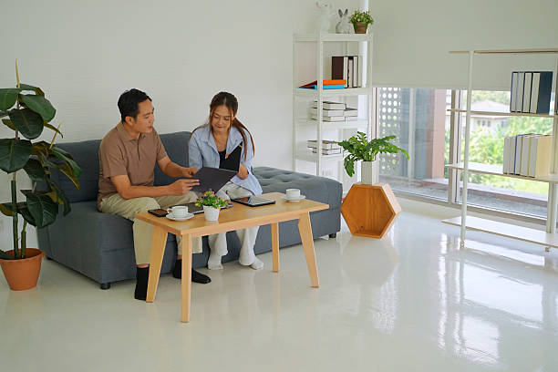 istock Couple working with digital device in living room. 2208936135