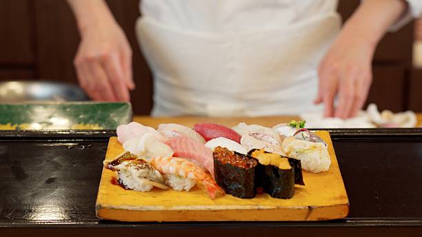 istock Chef's hands offering nigiri sushi 2208936597