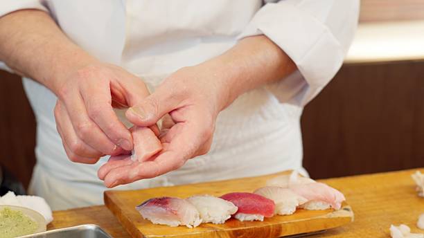 istock The hands of a chef preparing sushi 2208936598