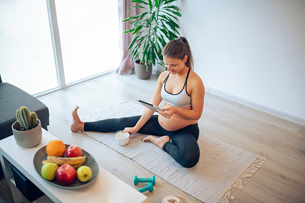 istock Pregnant woman doing relaxation exercising at home and using digital tablet. 2208939624