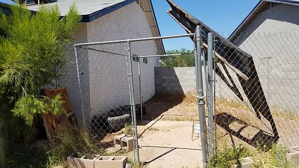istock Junk Accumulating behind Chain Link Fence in Yard, Blown from Storm 2208940508