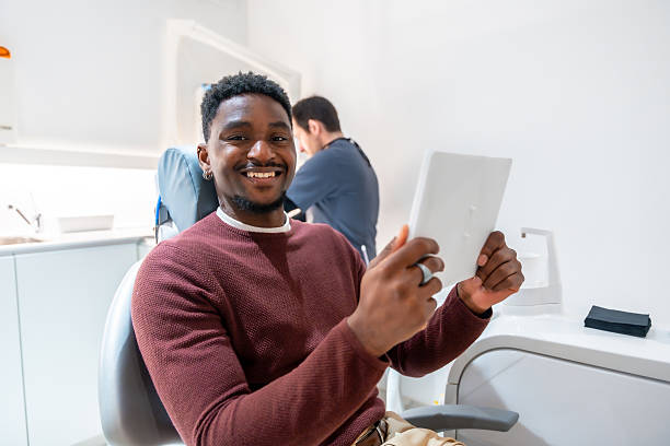 istock Patient smiling and using digital tablet at the dentist's office 2208940901