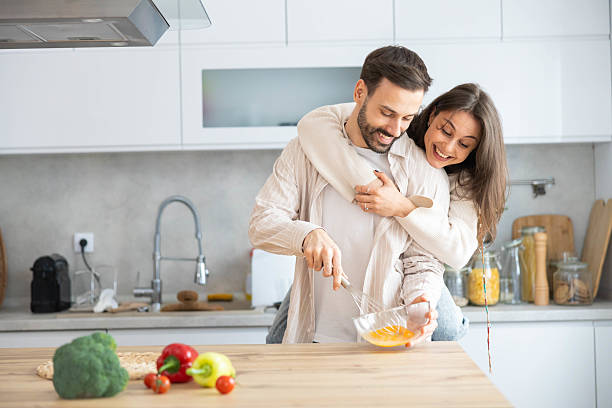 istock Smiling Couple Cooking in Trendy Kitchen 2208941657