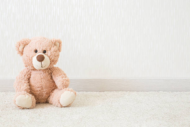 A soft, fluffy teddy bear plush toy rests on a cozy couch, illuminated by warm yellow light, creating an inviting atmosphere for relaxation and cherished moments with loved ones