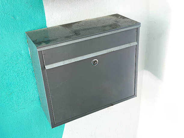 istock Wall-mounted metal mailbox on painted wall with key lock 2208953834