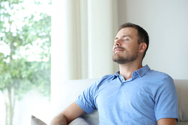 istock Man at home breathing fresh air on a sofa 2208954610