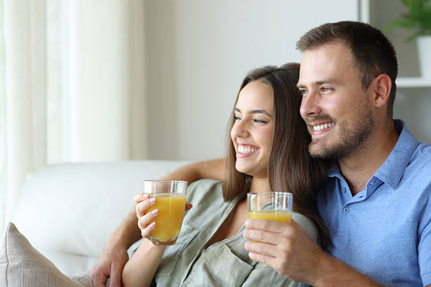 istock Happy couple at home relaxing drinking orange juice 2208954776