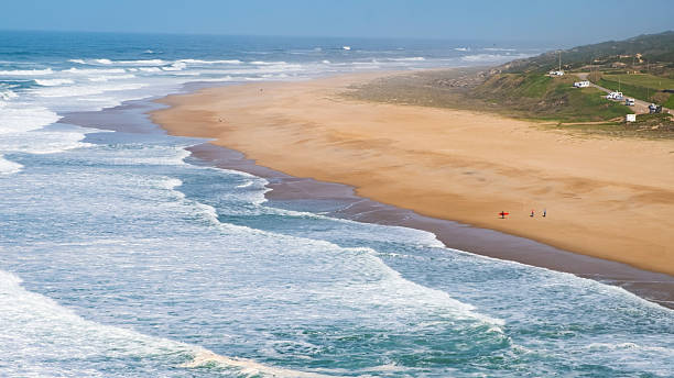 istock Aerial perspective capturing powerful waves breaking over sandy shoreline, surfers readying surfboards against dramatic portuguese coastal backdrop 2208955817