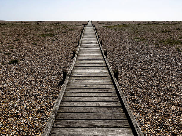 View along a timber walkway on the beach at Dungeness, East Sussex, UK.