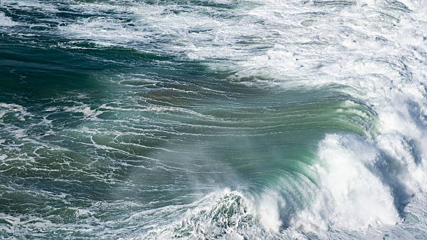 istock Giant ocean waves crash on the water surface forming a rainbow 2208957401