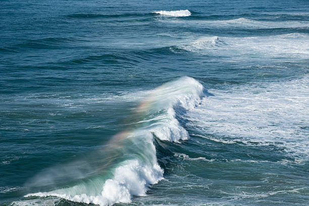 istock Giant ocean waves crash on the water surface forming a rainbow 2208957657