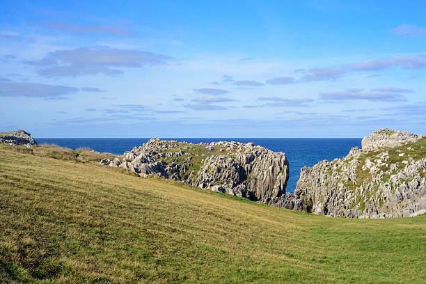 Blue sea horizon behind rocky shore
