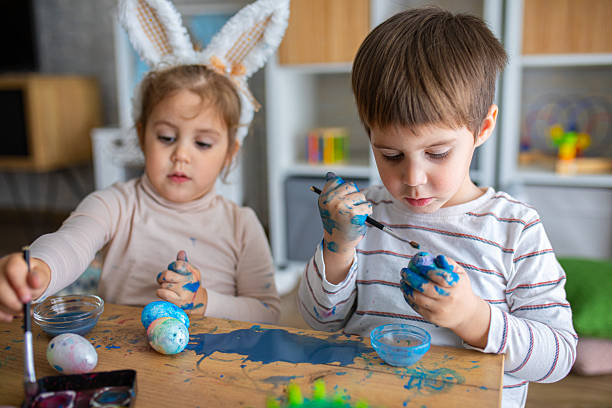 istock Two little kids painting eggs for Easter holiday 2208960113