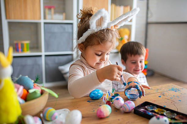 istock Kids having fun and playing while painting eggs for Easter holiday 2208960276