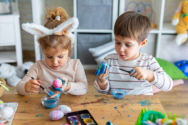 istock Two little kids painting eggs for Easter holiday 2208960839